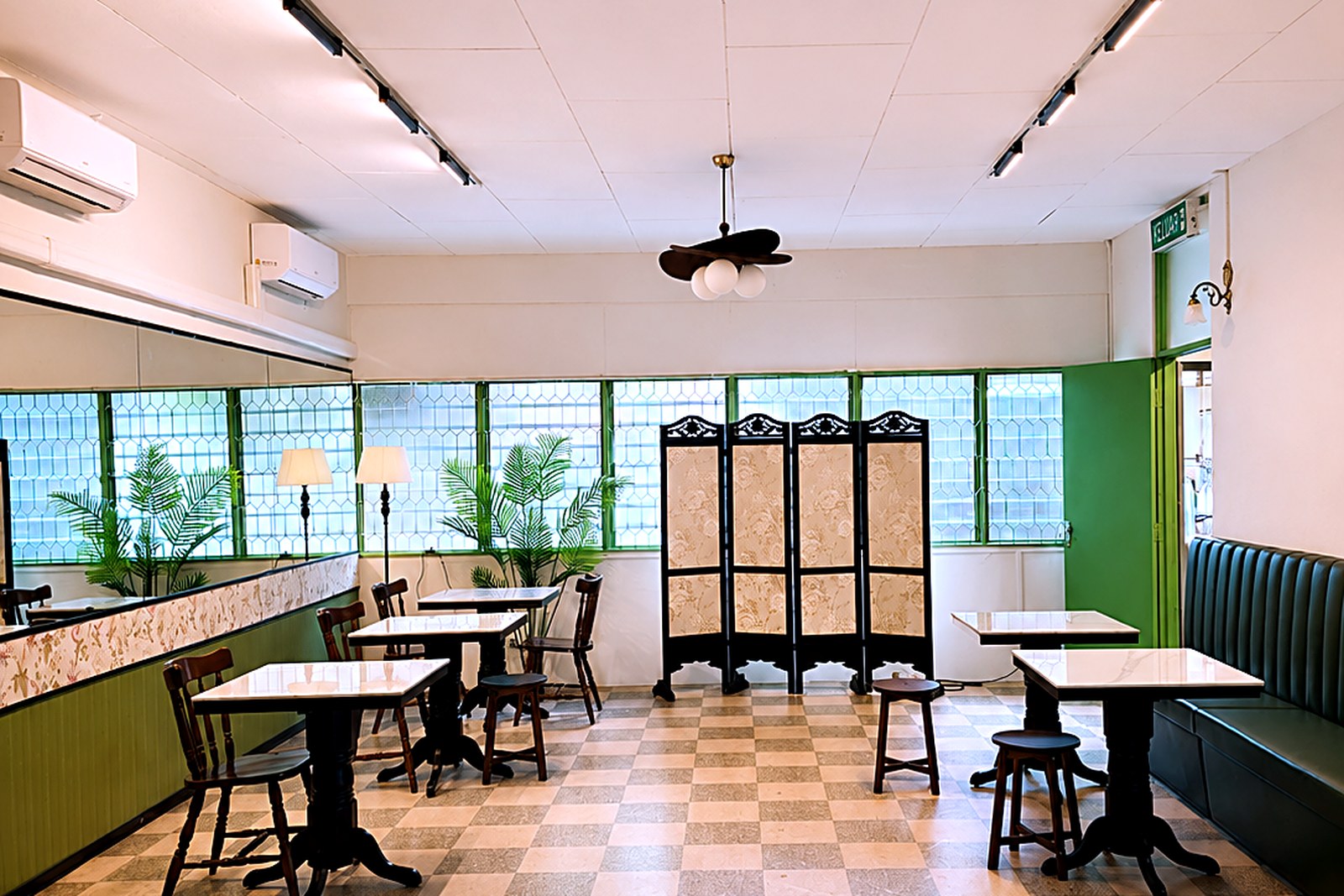 A shared lounge with tables, stools and a booth for working or relaxing