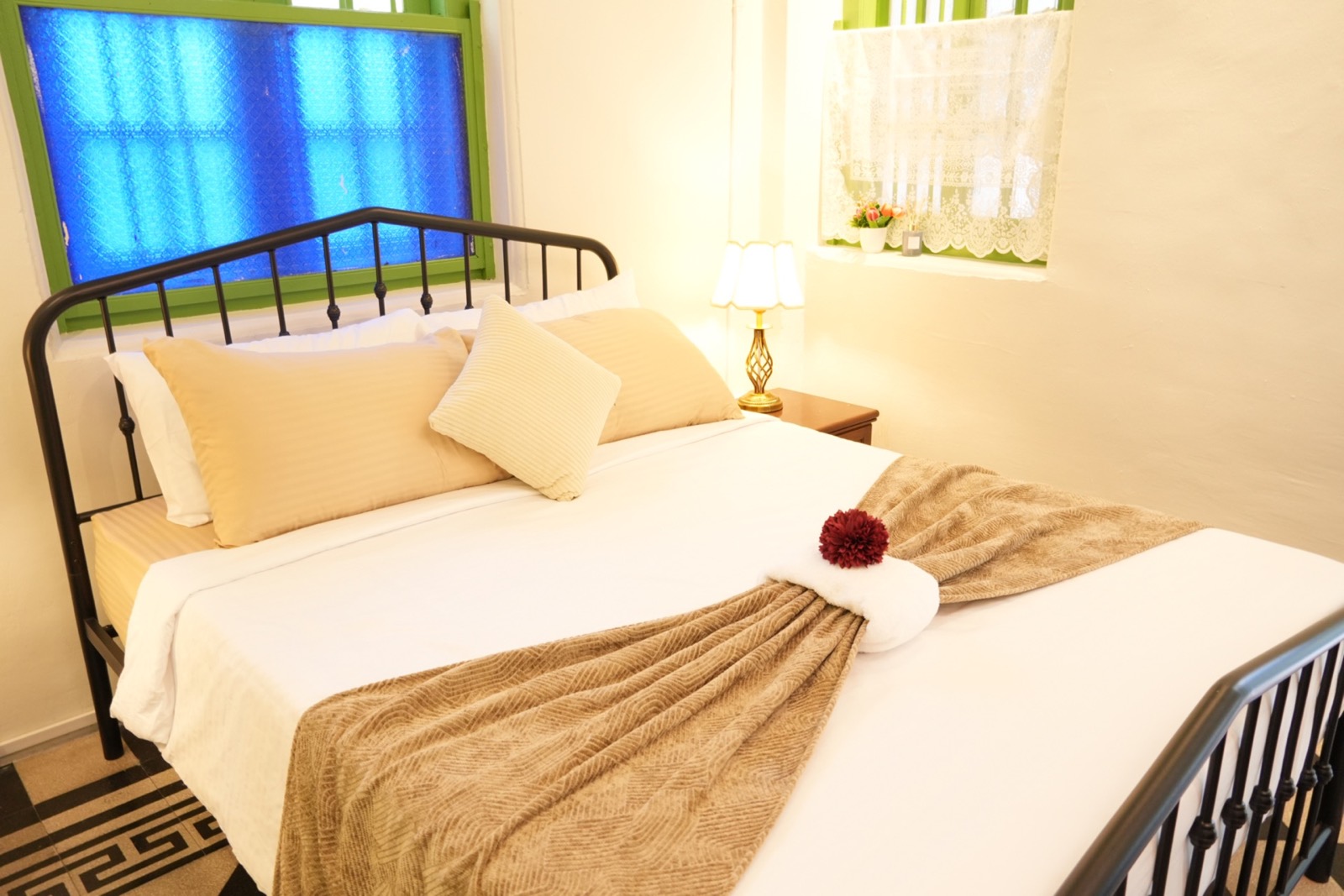 Guest bedroom framed by green timberwork and blue patterned glass