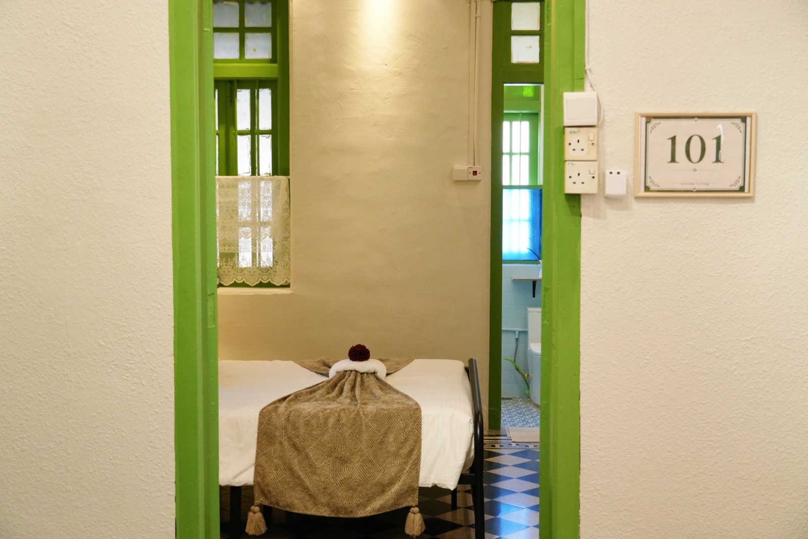 Room 101 viewed through its green doorway with ensuite beyond