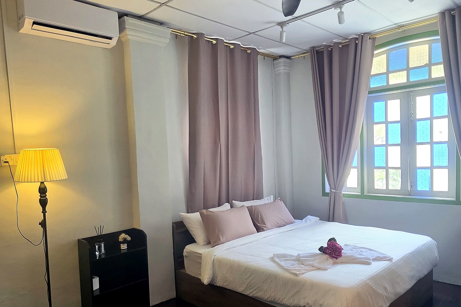 Room 203 with dusty-pink curtains and a warm reading lamp