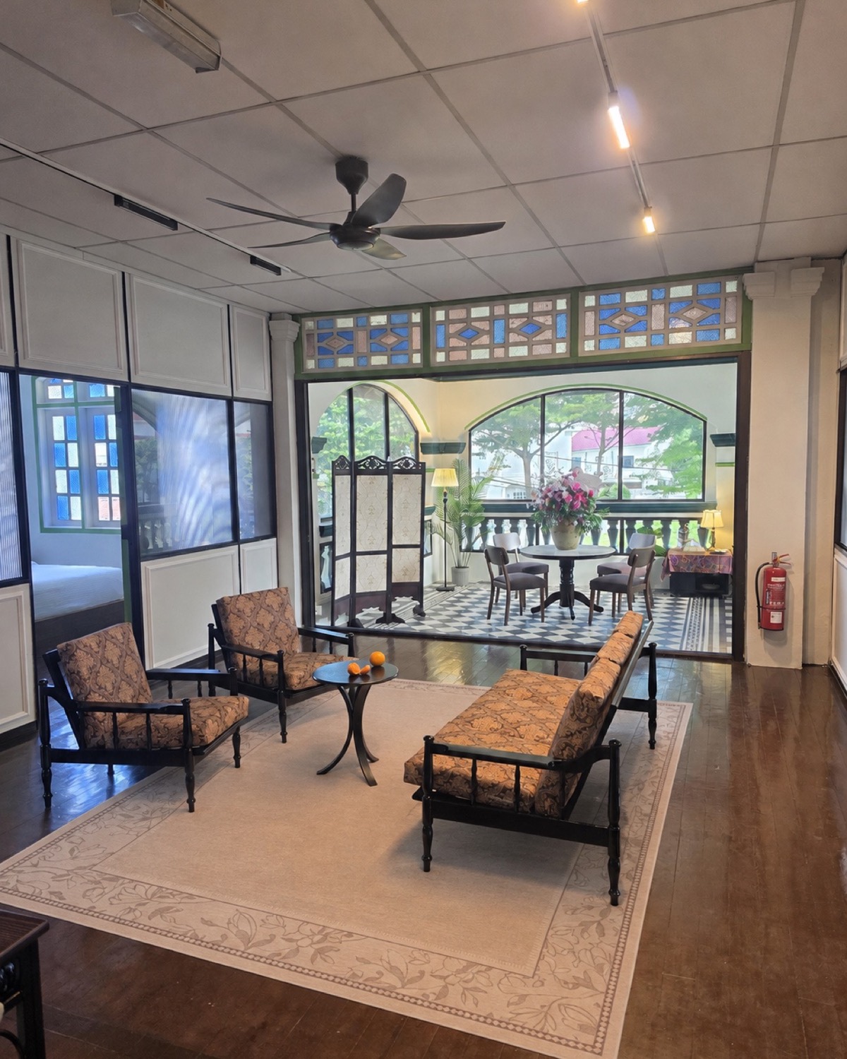 Upstairs communal lounge with heritage furniture and a bright veranda